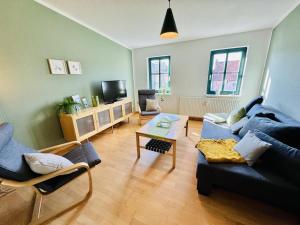 a living room with a blue couch and a table at Haus Juliane, Seesand in Warnemünde