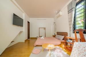 a bedroom with a bed and a table and a tv at Live like a local Homestay in Ấp Tư Tây