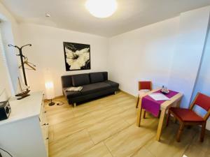 a living room with a black couch and a table at Haus Juliane, Sandstrand in Warnemünde +3 photos