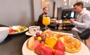 a table with a plate of food with fruit on it at First Hotel Amalie in Tromsø
