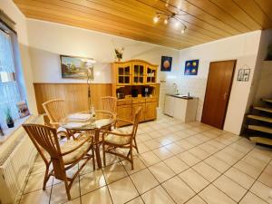 a dining room with a table and chairs and a kitchen at Ferienhaus Segelboot in Warnemünde