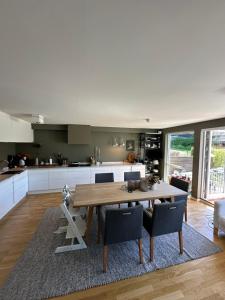 a kitchen with a wooden table and some chairs at Moderne enebolig, sentralt in Oslo