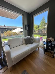 a living room with a white couch and a large window at Moderne enebolig, sentralt in Oslo