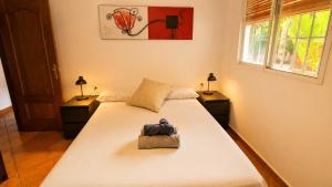 a bedroom with a white bed with a purse on it at Velez Nazari Cortijo Azud in Vélez de Benaudalla +37 photos