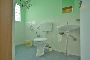 a bathroom with a toilet and a sink at Kaizen Stay-Inn in Jowai +17 photos