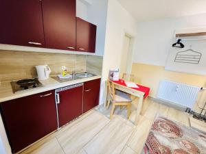 a small kitchen with red cabinets and a desk at Haus Juliane, Seepferdchen in Warnemünde