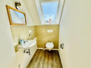 a bathroom with a toilet sink and a window at Ferienhaus Stoertebeker in Warnemünde +11 photos