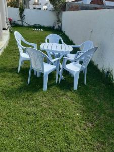 a group of white tables and chairs on the grass at Dar chat in Kelibia