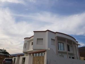 a white house with a car parked in front of it at Dar chat in Kelibia