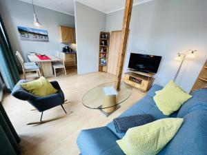a living room with a blue couch and a table at Haus Juliane, Strandliebe in Warnemünde