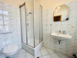 a bathroom with a shower and a toilet and a sink at Haus Juliane, Strandliebe in Warnemünde +8 photos