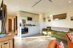 a living room with a couch and a kitchen at Hare Hill - Dog Friendly in Penicuik +17 photos