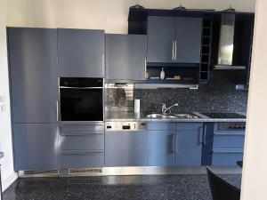 a kitchen with blue cabinets and a sink at Apartament Krzemienna in Bielsko-Biała +29 photos