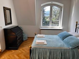 a bedroom with a bed with a dresser and a window at Apartament Krzemienna in Bielsko-Biała