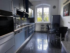 a kitchen with blue cabinets and a table and chairs at Apartament Krzemienna in Bielsko-Biała