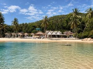 a beach with a group of houses and the water at Last Hammock Beach Resort in Baan Khai