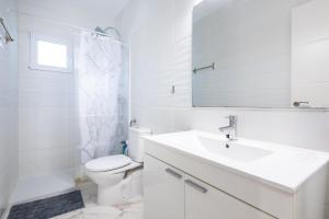 a white bathroom with a sink and a toilet at Apartamento Caracola in Vinarós +20 photos