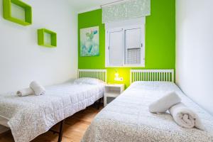 two beds in a room with green walls at Apartamento Caracola in Vinarós