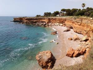 a beach with some rocks and the ocean at Apartamento Caracola in Vinarós