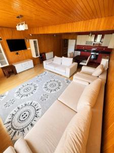 a large living room with white couches and a television at Ena Suites in Çaykara
