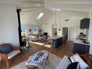a living room with a kitchen and a living room at Modern home, old charm! in Lake Hāwea