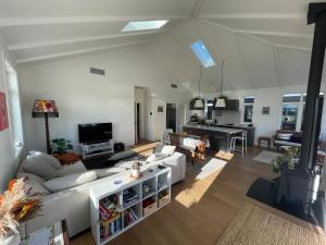 a living room with a couch and a table at Modern home, old charm! in Lake Hāwea +10 photos