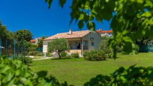 a house with a red roof in a yard at Villa MA by Villas Guide in Vodnjan