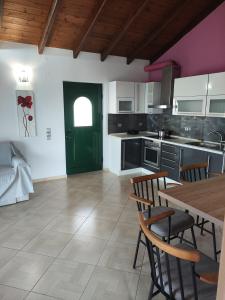 a kitchen with a table and chairs and a green door at Oasis Exclusive in Parga