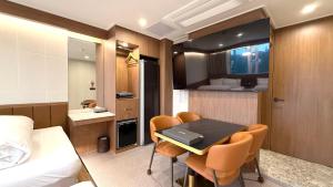 ein Zimmer mit einem Bett, einem Tisch und Stühlen in der Unterkunft Urban Brown Hotel in Gunsan