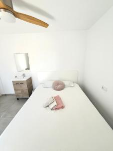 a bedroom with a white bed with a towel on it at Cisne By Nest Hostel in San Antonio
