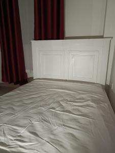 a white bed in a room with red curtains at BR Homes 2 Bedroom in Bungoma