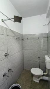 a bathroom with a toilet and a shower stall at Pynadath Square in Adūr