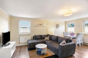 a living room with a couch and a tv at Ferienwohnung Grodenblick in Hooksiel
