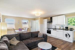 a living room with a couch and a kitchen at Ferienwohnung Grodenblick in Hooksiel