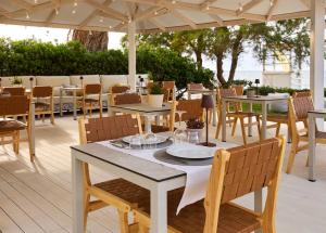 a table and chairs under an umbrella on a patio at Maravel Star Art Hotel in Adelianos Kampos