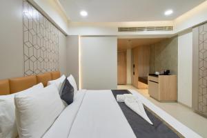a bedroom with a large white bed with white pillows at Hotel V Kondapur in Hyderabad +73 photos