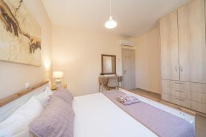 a bedroom with a large white bed in a room at Villa Malenia in Argostoli +15 photos