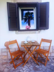 a table and two chairs and a palm tree in a window at More Garden in Opric