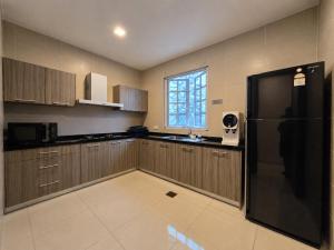 a kitchen with a black refrigerator and a window at Riverview Bungalow in Cameron Highlands in Tanah Rata