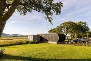 a house shaped like a barrel on a grass field at Scald Law in Penicuik