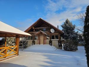 a house with a snow covered driveway in front of it at Outbreak 3 bedroom house with outdoor pool, BBQ and dining in Pirita in Corjova