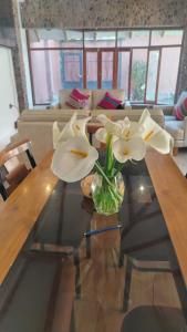 a vase of flowers on a table in a living room at Intikilla House in Cusco