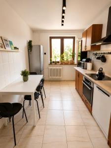 a kitchen with a table and chairs and a refrigerator at Zielone drzwi in Żywiec