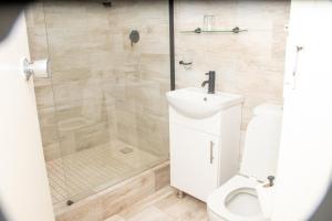 a bathroom with a shower with a sink and a toilet at Hotel Redcliff in Redcliff +24 photos