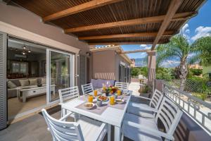 a patio with a white table and chairs on a deck at Villa Malenia in Argostoli