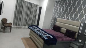 a bedroom with a bed with a blanket on it at Hotel Sunray in Tarn Tāran