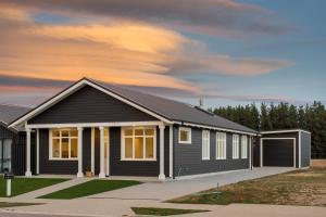 a home with a black house at Modern home, old charm! in Lake Hāwea