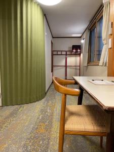 a room with a table and a green curtain at Popotel 3 Shaking Secret Room in Matsumoto