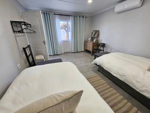 a bedroom with a bed and a desk and a window at Rosa's Self-catering in Springbok