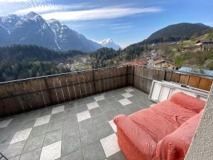a balcony with a bed and a view of mountains at La Casa del SEI SERIO in Pieve di Cadore